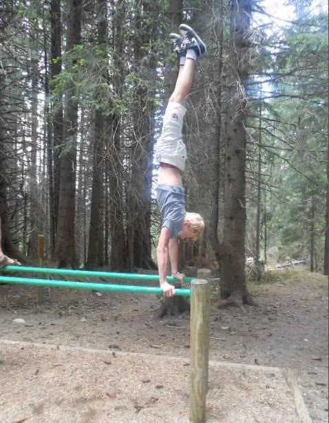 Sébastien à 11 ans, en handstand sur des barres parallèles en forêt